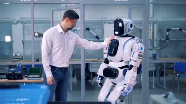 男性工人检查机器人平衡, 同时推动它。4k. — 图库视频影像