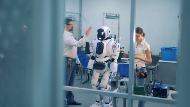 Ingenieurs testen robots bewegingen, kijken naar het draaien. — Stockvideo