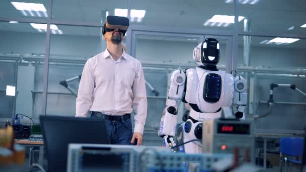 Férfi dolgozó és a robot, hogy mozgás a karok. Virtuális valóság játék. — Stock videók