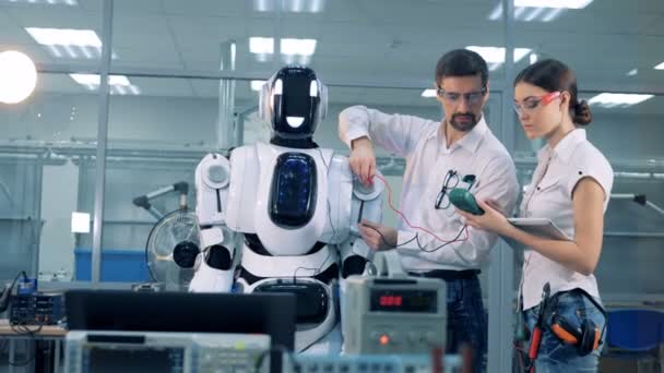 Ingenieurs controleren robots spanning. — Stockvideo