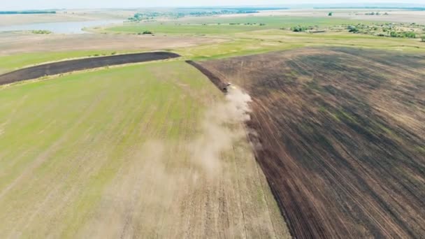 Вид зверху на величезне поле, яке сіяє трактор — стокове відео