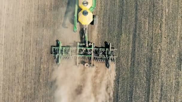 El tractor de dispersión se mueve a lo largo del prado y lo siembra. Antena . — Vídeo de stock