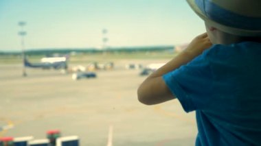 Uçaklar arayan bir çocuk kapatın. Bir çocuk oturur ve Havaalanı Pist görünüyor.