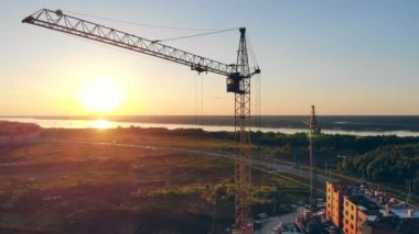 Gün batımı bir arka plan üzerinde inşaat vinç. Emlak kavramı.