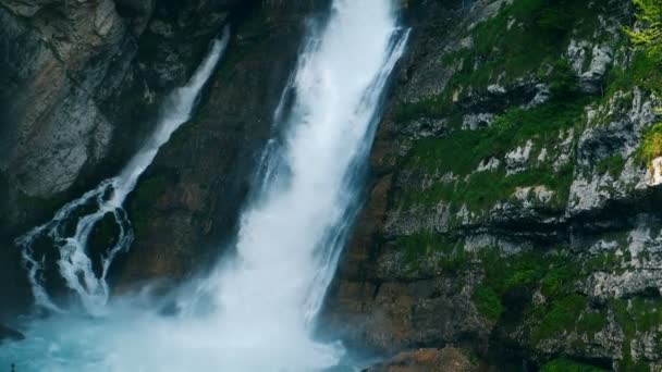 Uma grande cachoeira nas montanhas. A água está fluindo pela cachoeira em câmera lenta . — Vídeo de Stock