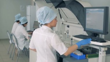 Hemşire modern otomatik tıbbi ekipman üzerinde test süreci yönetir.