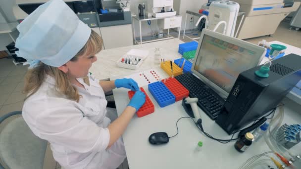 Pracownik laboratorium przenosi Dokonywanie testy medyczne w nowoczesnym laboratorium próbek krwi. — Wideo stockowe
