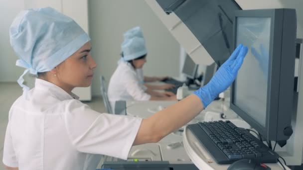 Tipos de trabajadores de laboratorio en un monitor de una máquina, de cerca . — Vídeos de Stock