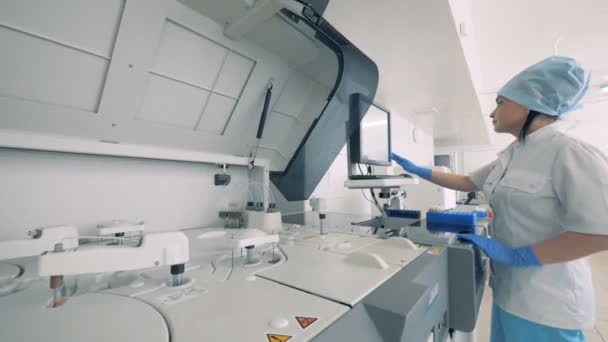 Una enfermera trabaja con una máquina de análisis de sangre . — Vídeo de stock