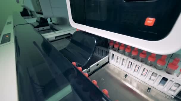 Muitas amostras de sangue são verificadas em uma máquina automatizada médica especial, movendo-se em uma linha . — Vídeo de Stock