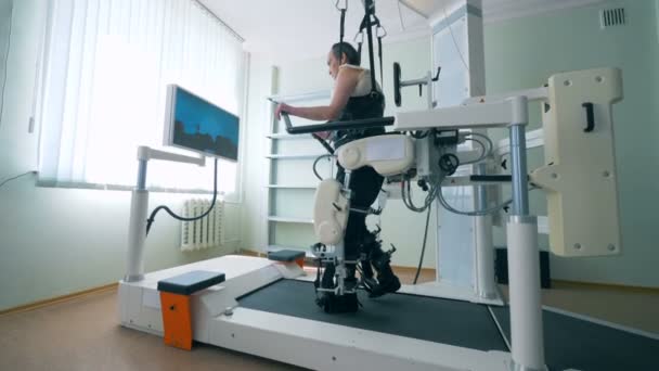 Moderna medicinska återhämtning enhet. Utbildning processen av en fysiskt utmanade man på en walking simuleringssystem — Stockvideo