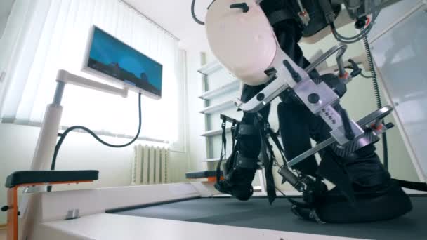 Elektroniska medicinska robotic för rehabilitering. Patienten tränar för att gå på en speciell maskin — Stockvideo