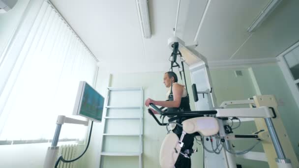 Gehandicapte persoon op een moderne robotic medische herstel-apparatuur. Medische robot. — Stockvideo