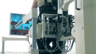 Belden aşağısı felçli kişi özel bir makine üzerinde yürüme simülasyonu. 4k