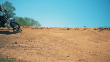 Sportbikes sürücü kirli arazi üzerinde zikzaklar içinde hareket ediyor. Ağır çekim