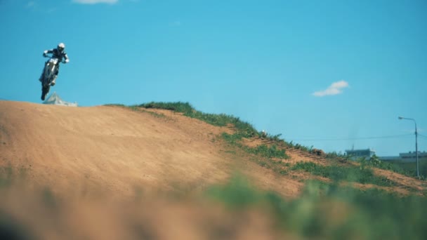 Slow motion beelden van een motorcyclers sprong boven de heuvel. Slow motion — Stockvideo