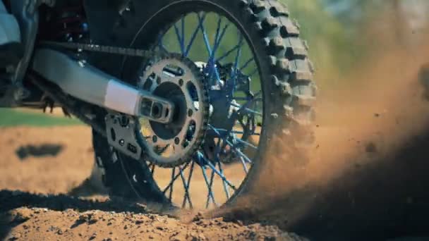 Крупным планом колес автобайка запускает движение и поднимает облака пыли — стоковое видео
