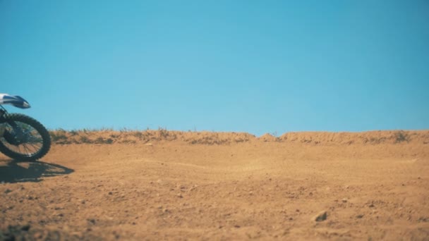 FMX biker is rijden door stof met zijn benen omhoog in de lucht. Slow motion — Stockvideo