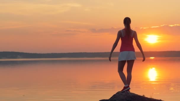 Woman does yoga near lake. — Stock Video