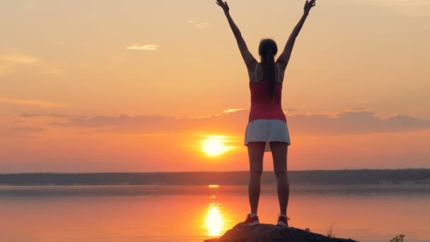 A woman stretches up on a lake. — Stock Video