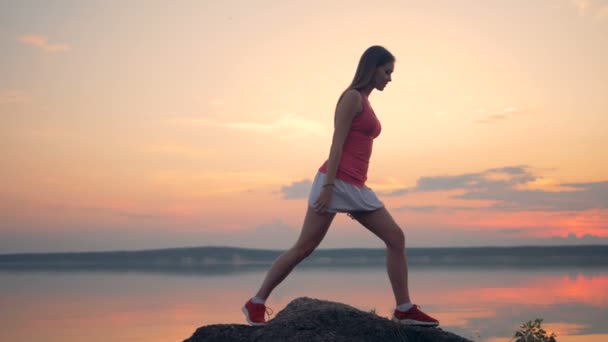 Fitness girl faz ioga em uma rocha . — Vídeo de Stock