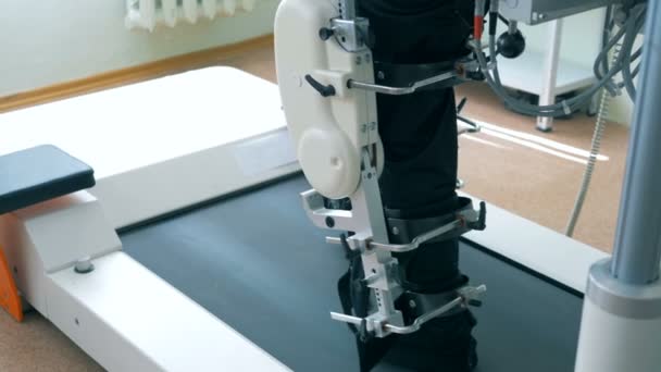 Close up of legs of a male patient getting trained by a track machine — Stock Video