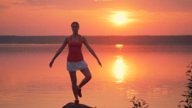 Genç ve güzel kadın bir göl kıyısında bir eğitim duruş evlat edinmek