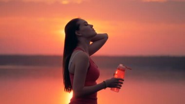 Untressed saçları düz ve açık havada içki genç kadın