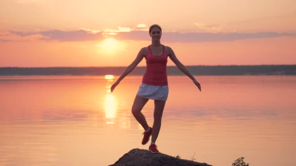 Proceso de entrenamiento de una dama guapa cerca de un lago al amanecer — Vídeo de stock