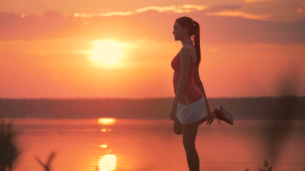 Mujer joven y saludable está estirando sus músculos con un ejercicio especial — Vídeo de stock