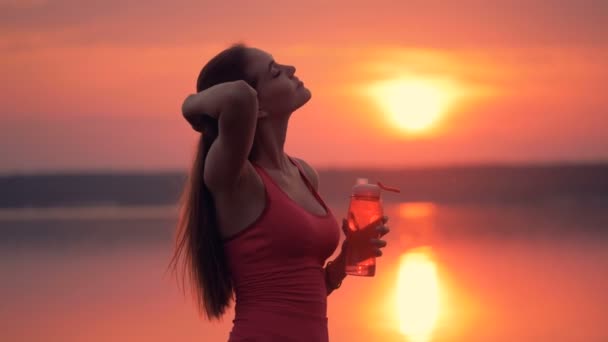 Pintoresco paisaje con una delgada joven bebiendo de una botella — Vídeos de Stock