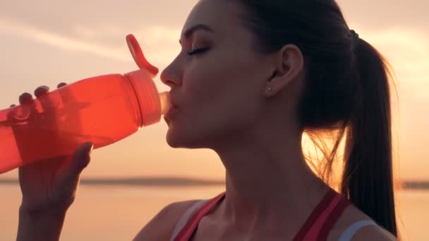 日光の下で水を飲んでいる間美しい女性の顔のクローズ アップ — ストック動画