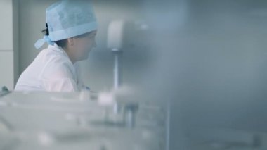 Hastane çalışanları oturan ve donanımlı bir laboratuvarda çalışan
