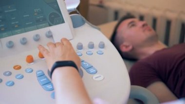 Bir adam bir sonic konsolda yapılan ultrason yordamı geçiyor