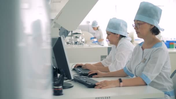 Duas funcionárias médicas trabalham num laboratório. — Vídeo de Stock