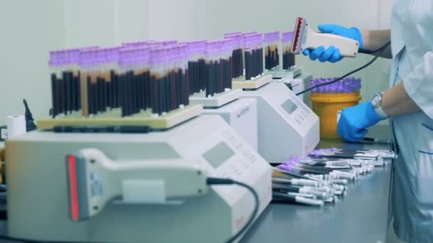 Medical worker is registering test tubes with a scanner — Stock Video