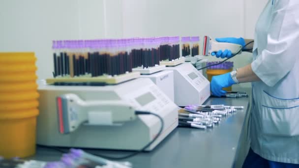 Эксперт лаборатории вставляет пробирки с образцами в испытательные машины — стоковое видео