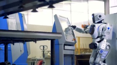 Robot, robot düğmesine basınca bir endüstriyel makine üzerinde.