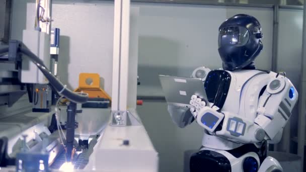 Een robot in zwarte helm typen op een Tablet PC. — Stockvideo