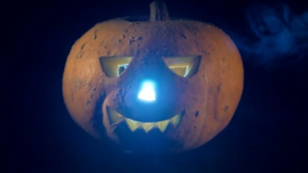 Filmagem de uma valete-o-lanterna brilhante. Assustador esculpida abóbora halloween . — Vídeo de Stock