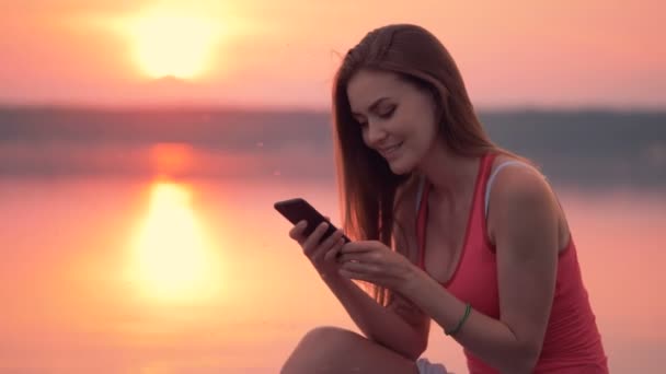 Uma menina digita em seu telefone sentado em uma nuvem de insetos . — Vídeo de Stock