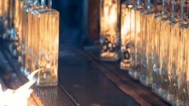 Alev, yakındaki bir konveyör şişe yakın çekim.