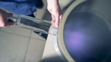 İşçi inceler bir şişe, üstten görünüm.