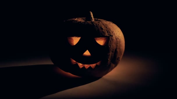 Halloween celebration concept. Dark room with a glowing halloween pumpkin in it — Stock Video