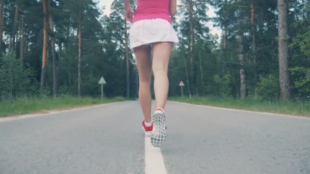 Vista posteriore di una parte inferiore del corpo femminile mentre fai jogging al rallentatore — Video Stock