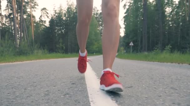 Filmagem em câmera lenta de pernas femininas correndo ao longo do beco em uma visão frontal — Vídeo de Stock