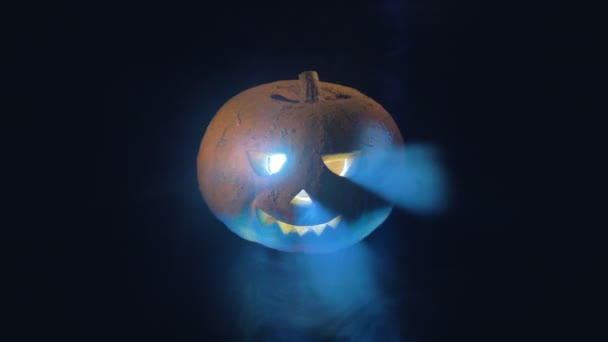 Gloeiende halloween pompoen in de wolken van rook en lichtflitsen. Happy halloween pompoen concept. — Stockvideo