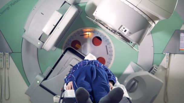 Paciente masculino se somete a un procedimiento médico con una máquina de linac — Vídeo de stock