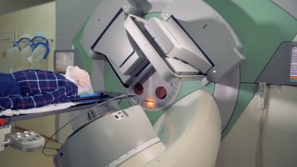 Linac kretsar kring en patient under strålbehandling — Stockvideo