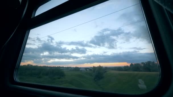 Spoorweg reis concept. Treinen venster met twilight landschap gefilmd door het — Stockvideo